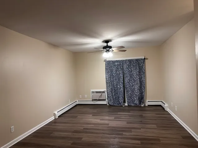 a view of wooden floor in an empty room with a chandelier