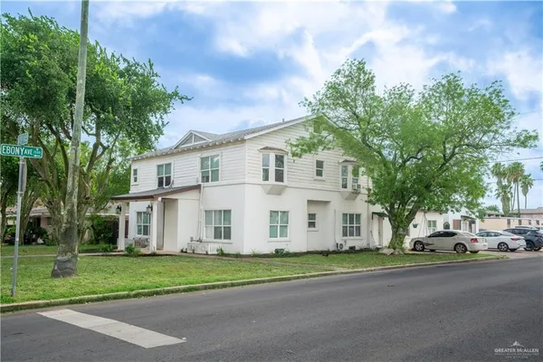 a view of a white house with a street