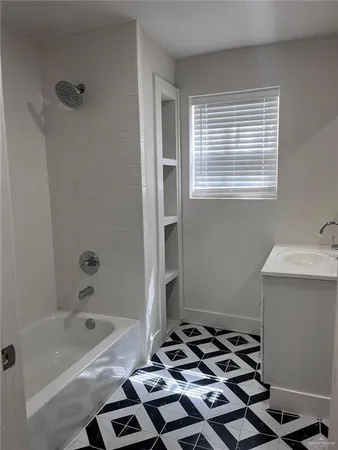 an empty room with wooden floor fireplace and windows