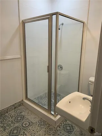 an empty room with wooden floor chandelier fan and windows