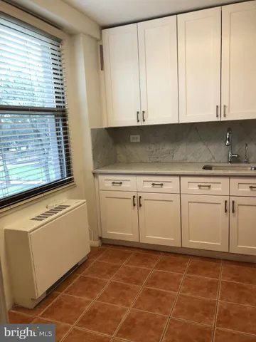 a kitchen with stainless steel appliances granite countertop white cabinets stove top oven and sink