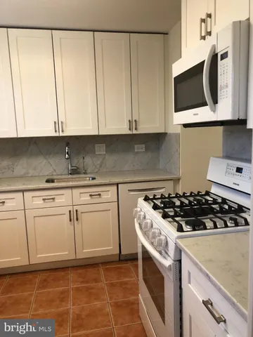 a stove top oven sitting inside of a kitchen