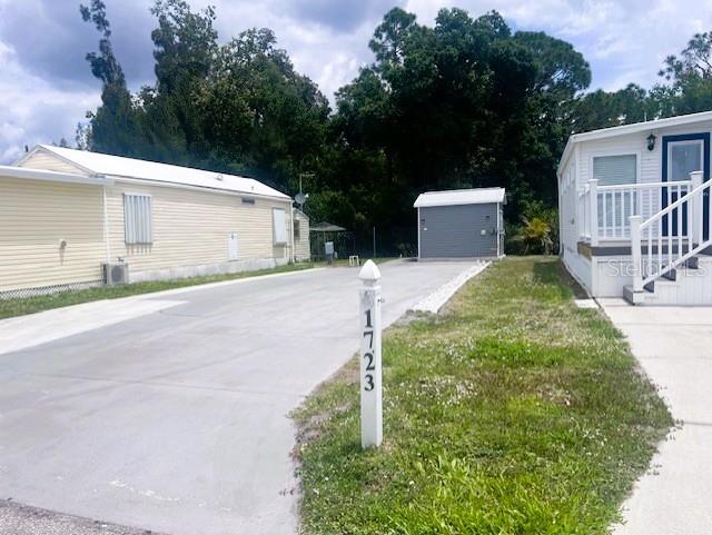 1723 East Manatee Loop Punta Gorda, FL 33950 - Photo 2 of 17 a front view of a house with a yard and trees