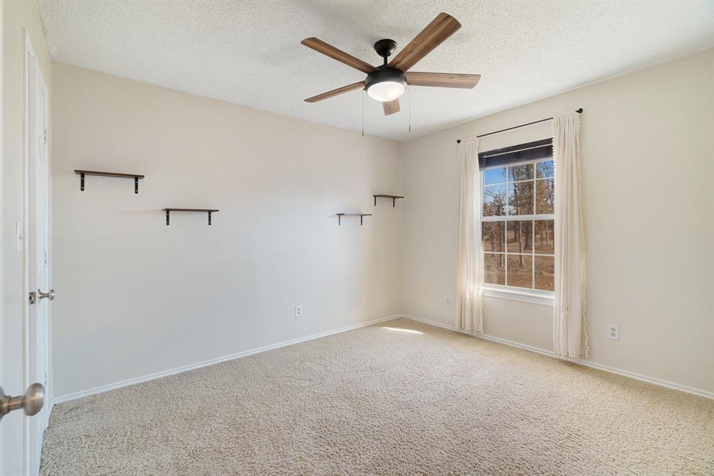 201 County Road Powderly, TX 75473 - Photo 14 of 26 an empty room with a ceiling fan and windows