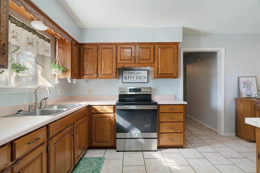 201 County Road Powderly, TX 75473 - Photo 5 of 26 a kitchen with stainless steel appliances granite countertop a stove a sink and a refrigerator