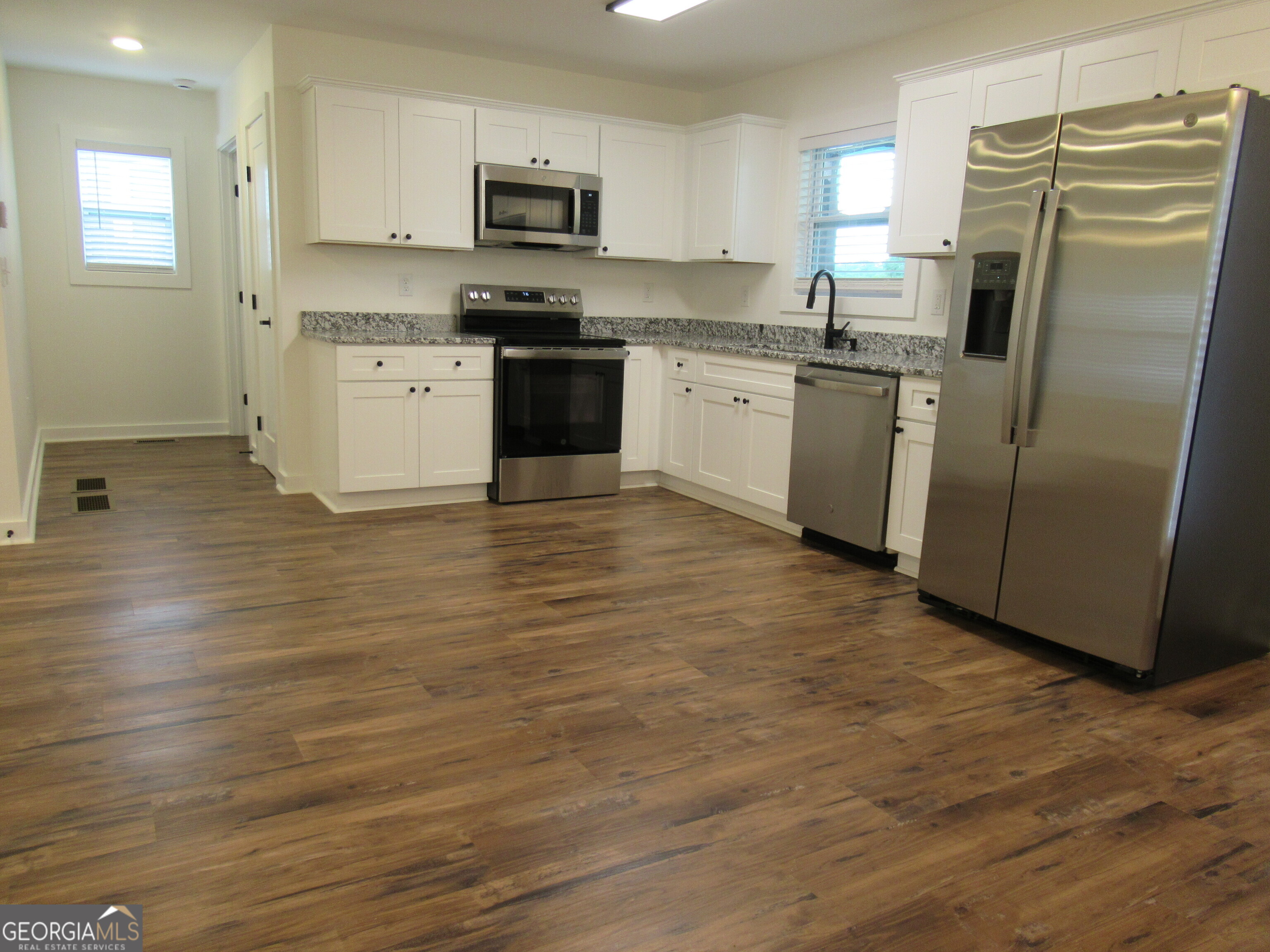 765 Old Kerns Road Dawsonville, GA 30534 - Photo 17 of 36 a kitchen with stainless steel appliances a stove a refrigerator sink and microwave
