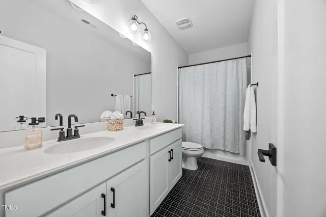 a bathroom with double vanity sink and a mirror