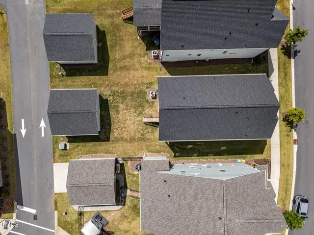 an aerial view of residential houses with outdoor space and parking