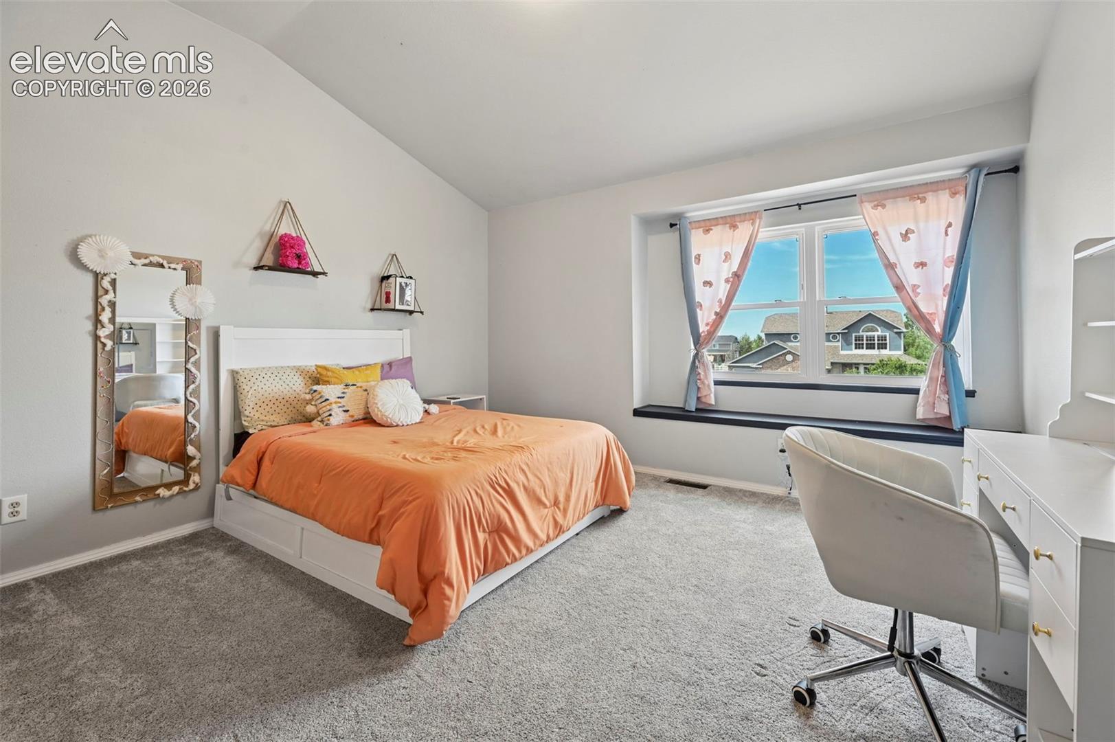 8347 Tibbs Road Peyton, CO 80831 - Photo 14 of 38 Spacious room with a vaulted ceiling and light gray walls
