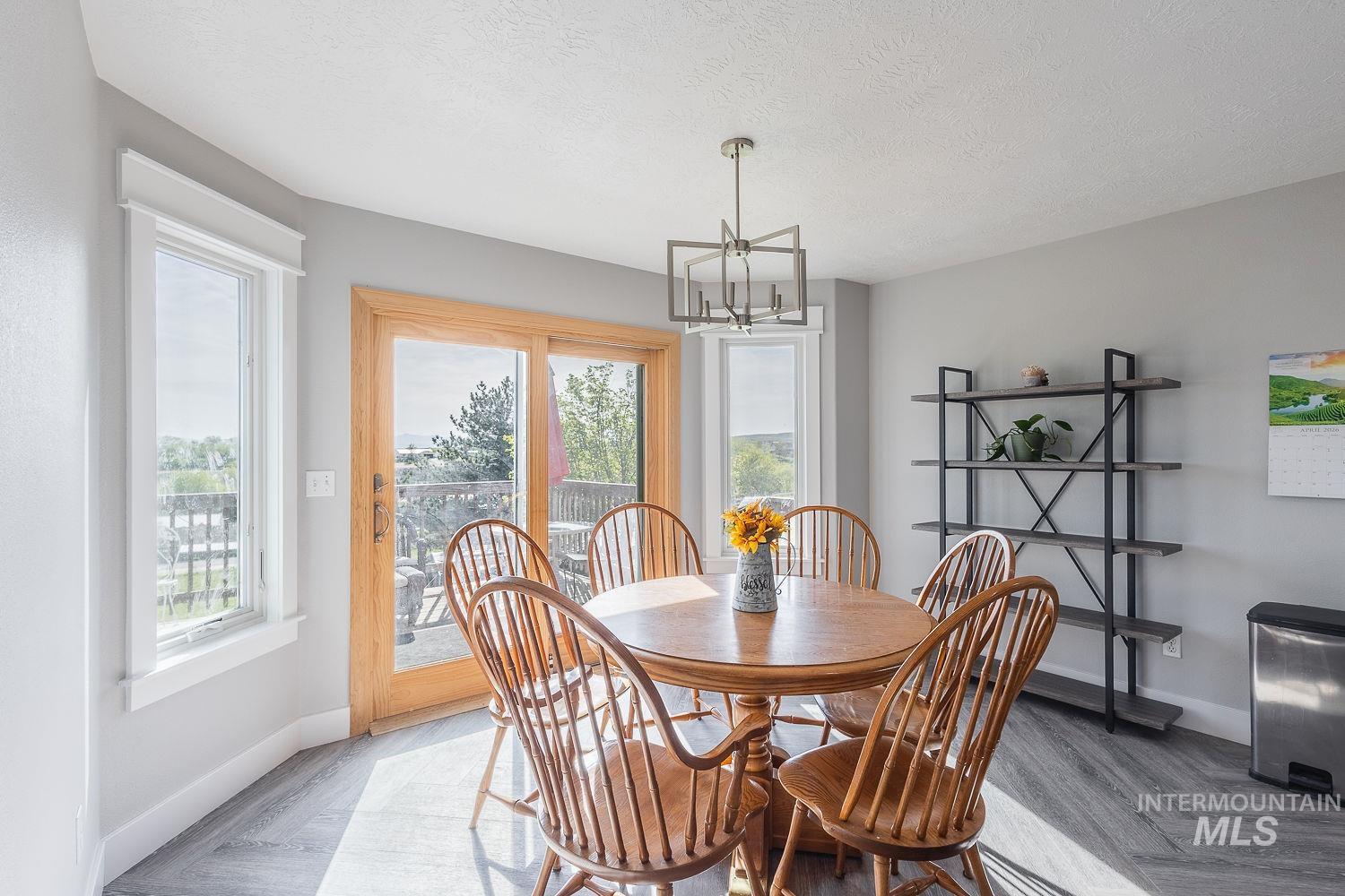 3950 Cassia Road New Plymouth, ID 83655 - Photo 12 of 26 Dining space featuring suspended lighting, parquet floors, and a textured ceiling