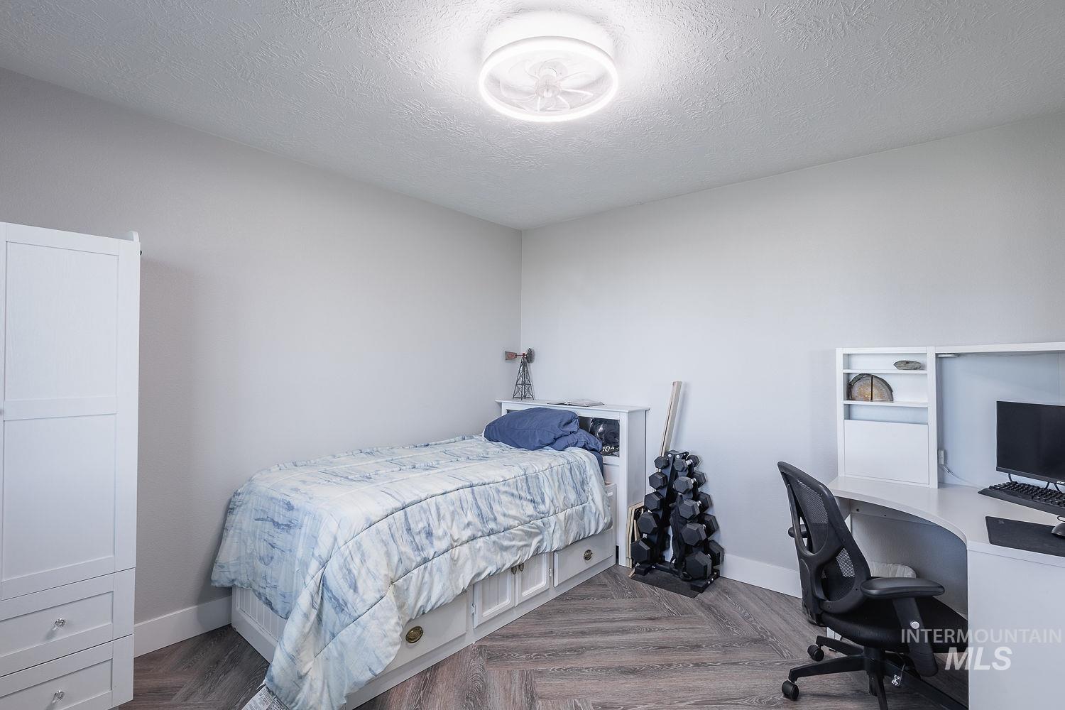 3950 Cassia Road New Plymouth, ID 83655 - Photo 18 of 26 Bedroom with a desk, parquet floors, and a textured ceiling