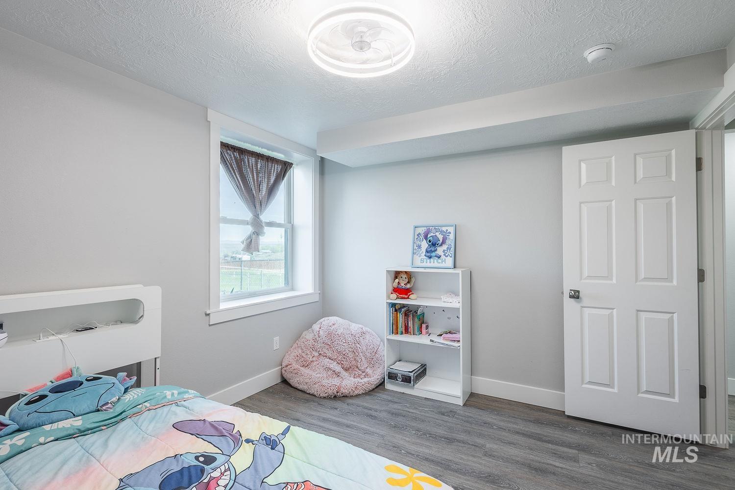 3950 Cassia Road New Plymouth, ID 83655 - Photo 19 of 26 Bedroom featuring dark wood-style floors and a textured ceiling