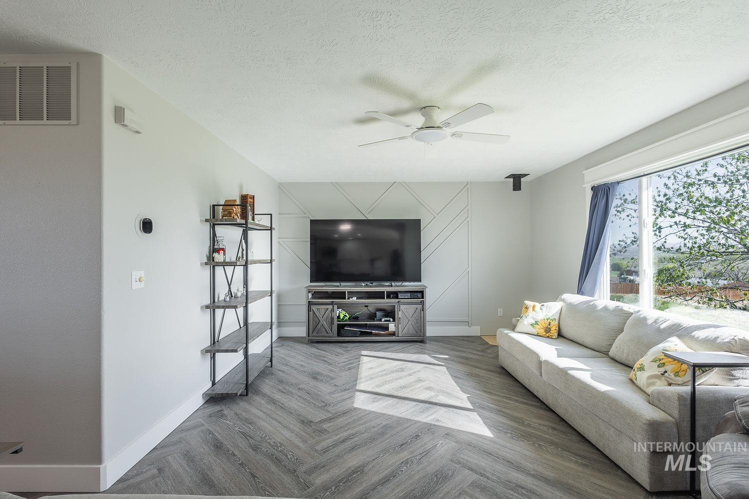 3950 Cassia Road New Plymouth, ID 83655 - Photo 10 of 26 Living area featuring parquet floors, ceiling fan, and a textured ceiling