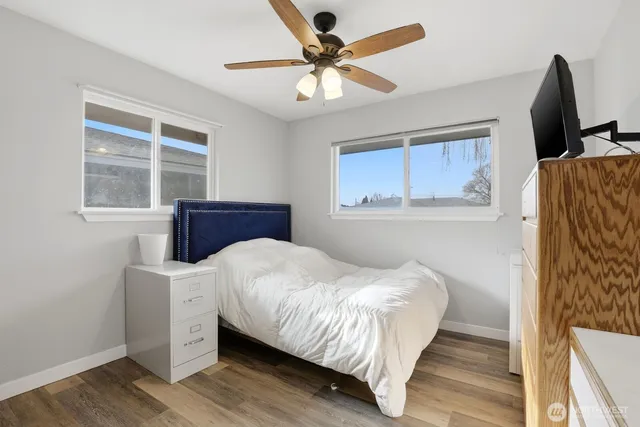 a bedroom with a bed and a flat tv screen on dresser