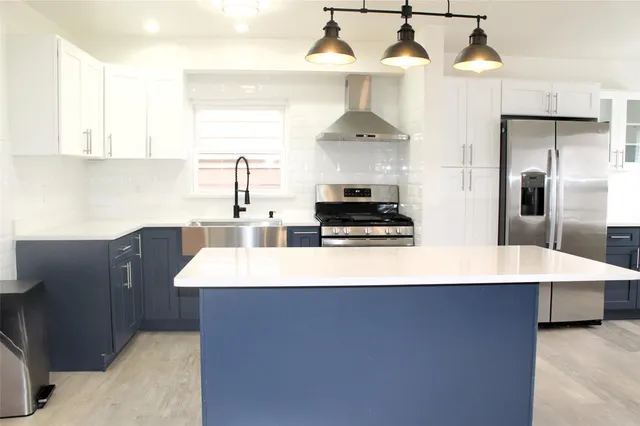 a kitchen with stainless steel appliances a sink stove and refrigerator