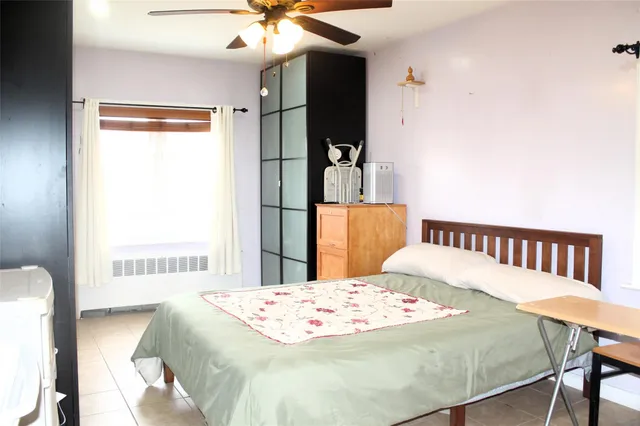 a bedroom with a bed and a table in it with wooden floor