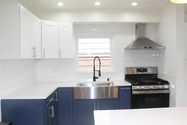 a kitchen with kitchen island stainless steel appliances a sink stove and refrigerator