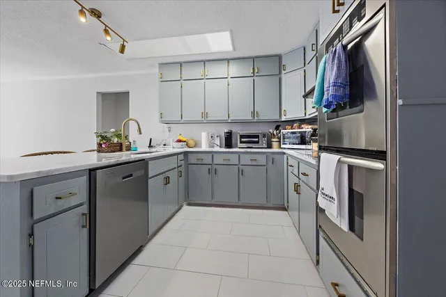 a kitchen with a sink cabinets and stainless steel appliances