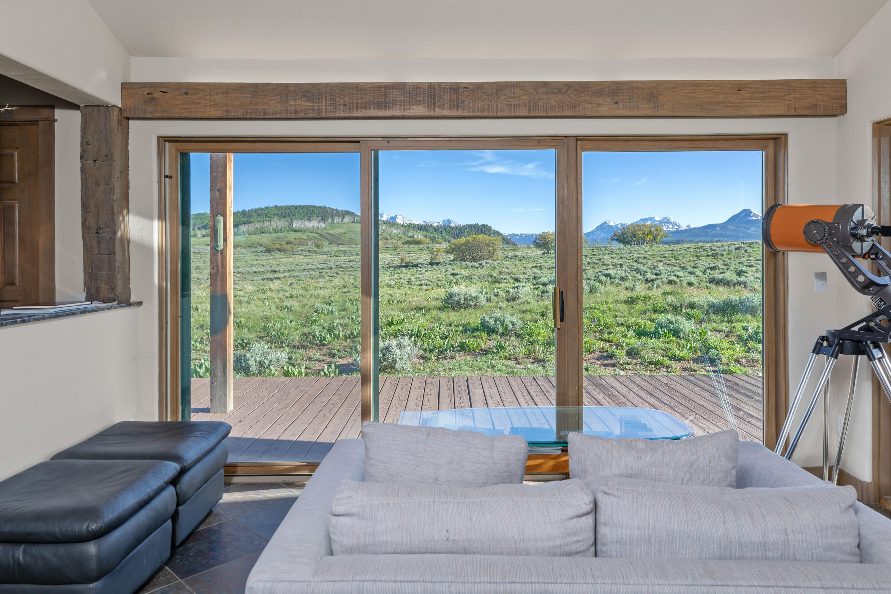 541 Elam Ridge Drive Placerville, CO 81430 - Photo 12 of 36 a living room with a floor to ceiling window and a table