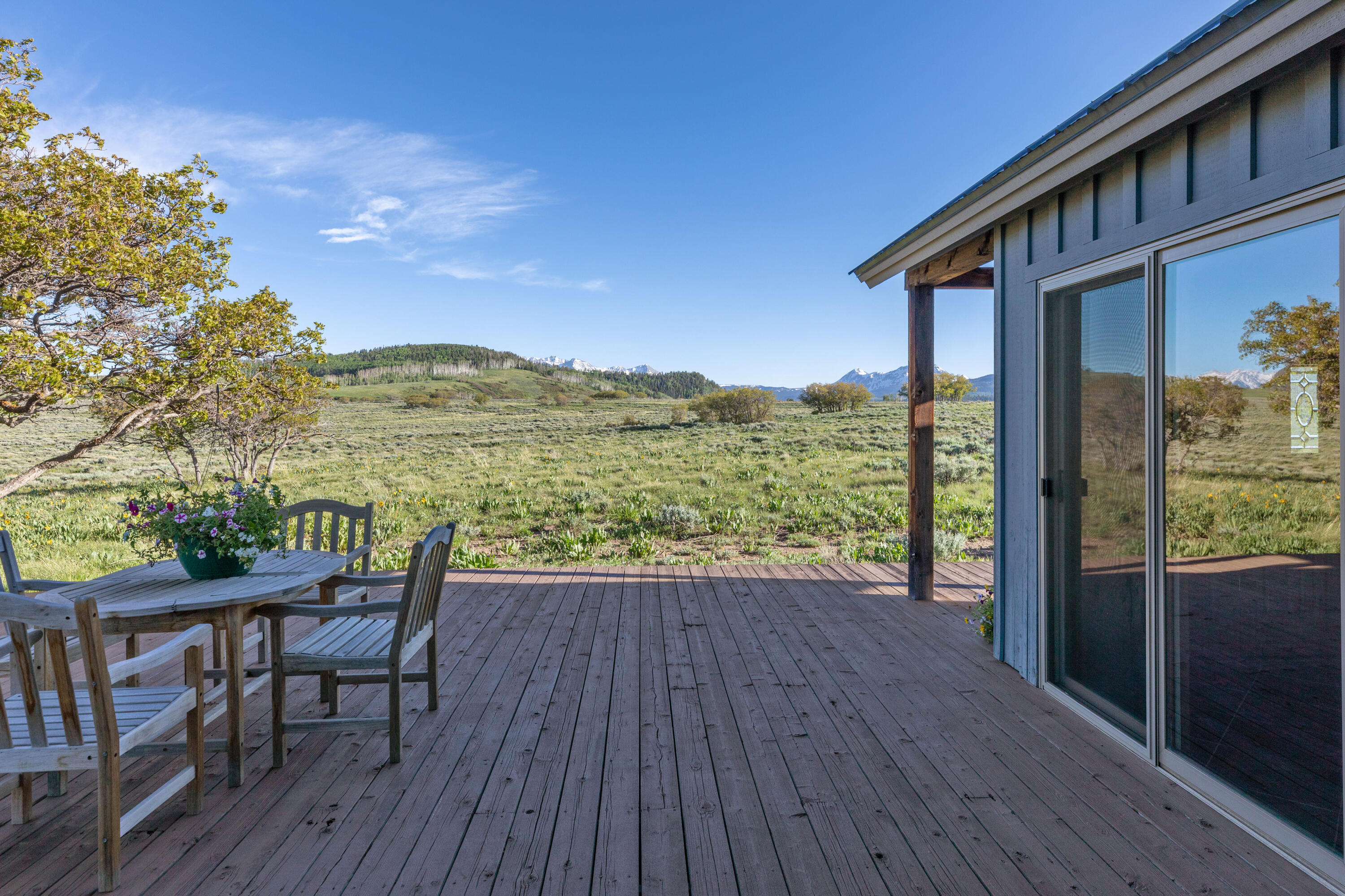 541 Elam Ridge Drive Placerville, CO 81430 - Photo 15 of 36 a view of a balcony with table and chairs and wooden floor