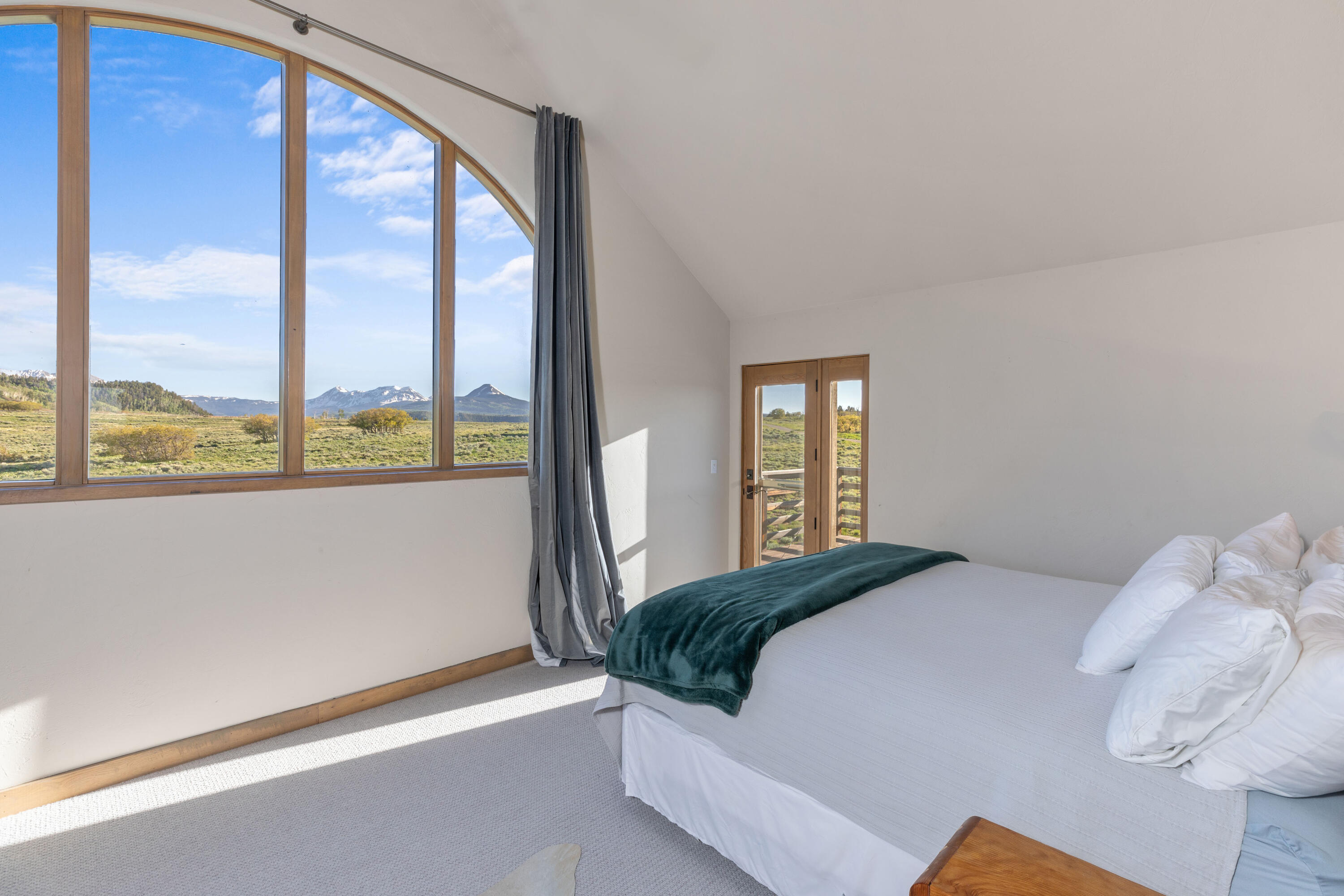 541 Elam Ridge Drive Placerville, CO 81430 - Photo 17 of 36 a bedroom with a large bed and a large window