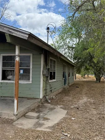 a front view of a house with a tree