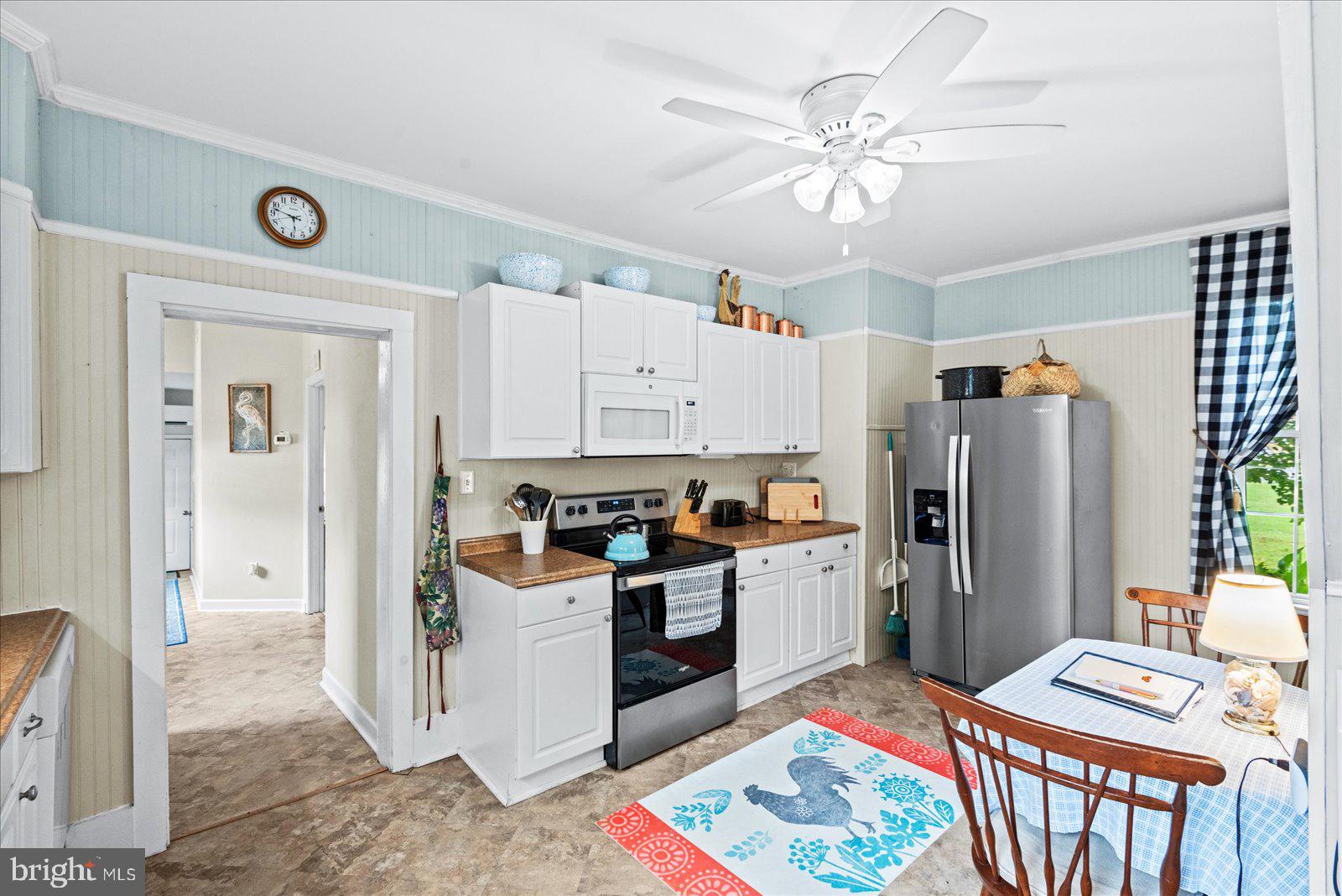 209 Hawthorn Street Colonial Beach, VA 22443 - Photo 15 of 56 a kitchen with stainless steel appliances a stove a refrigerator and a chandelier