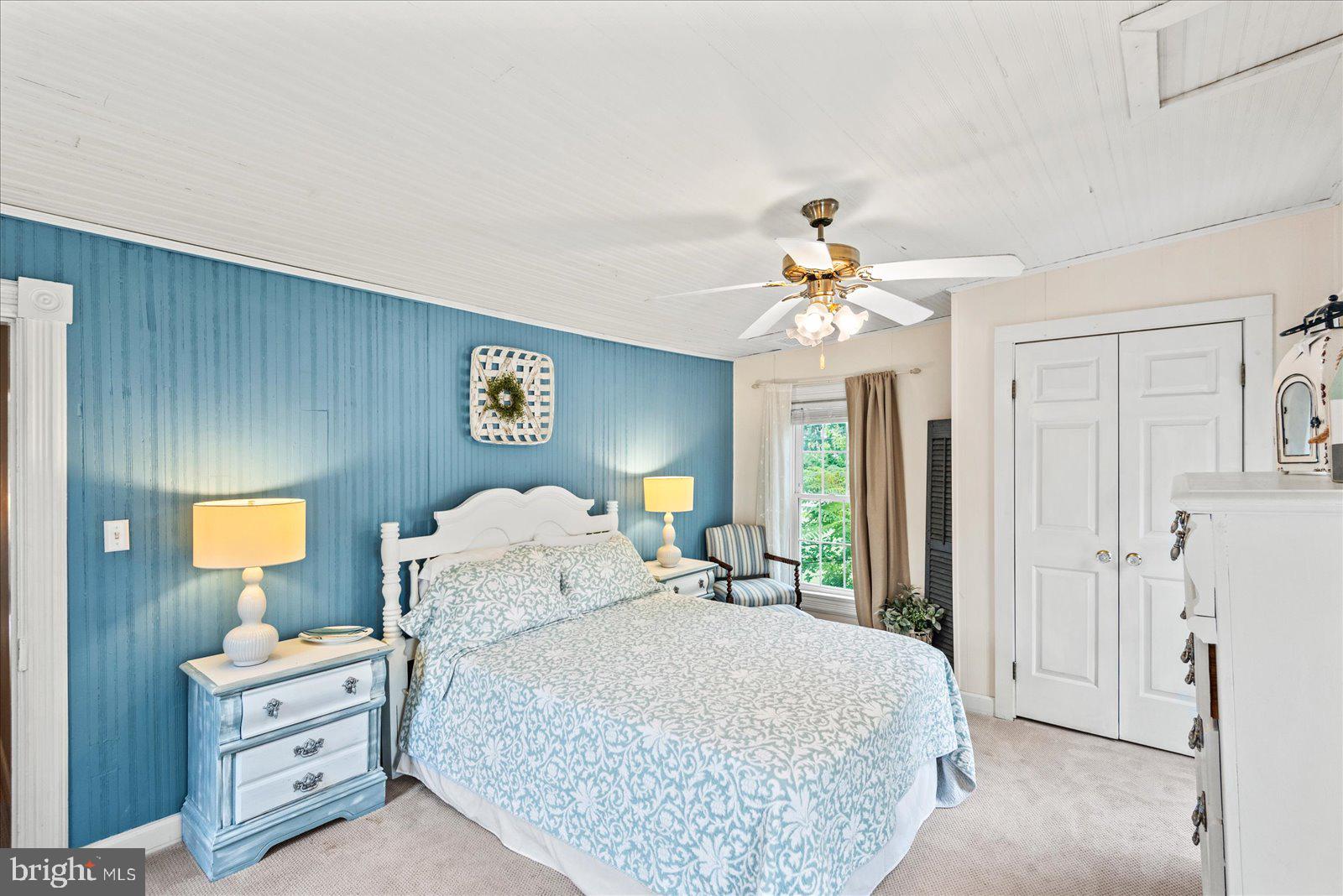 209 Hawthorn Street Colonial Beach, VA 22443 - Photo 28 of 56 a spacious bedroom with a bed and a chandelier