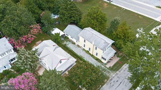 an aerial view of a house with a yard and a large tree