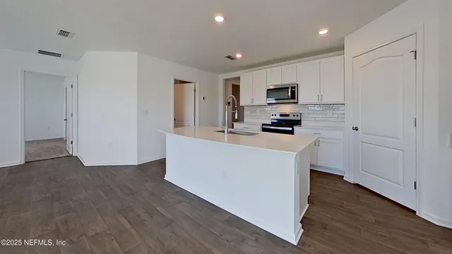 a kitchen with cabinets a sink and a stove top oven