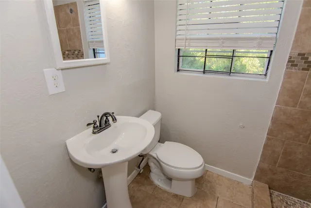 a bathroom with a toilet sink and mirror