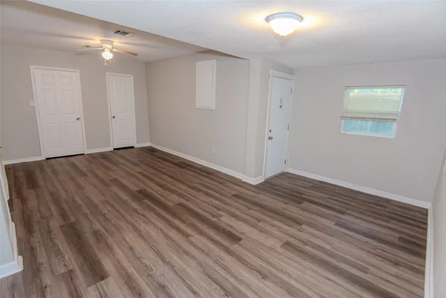 a view of an empty room with wooden floor