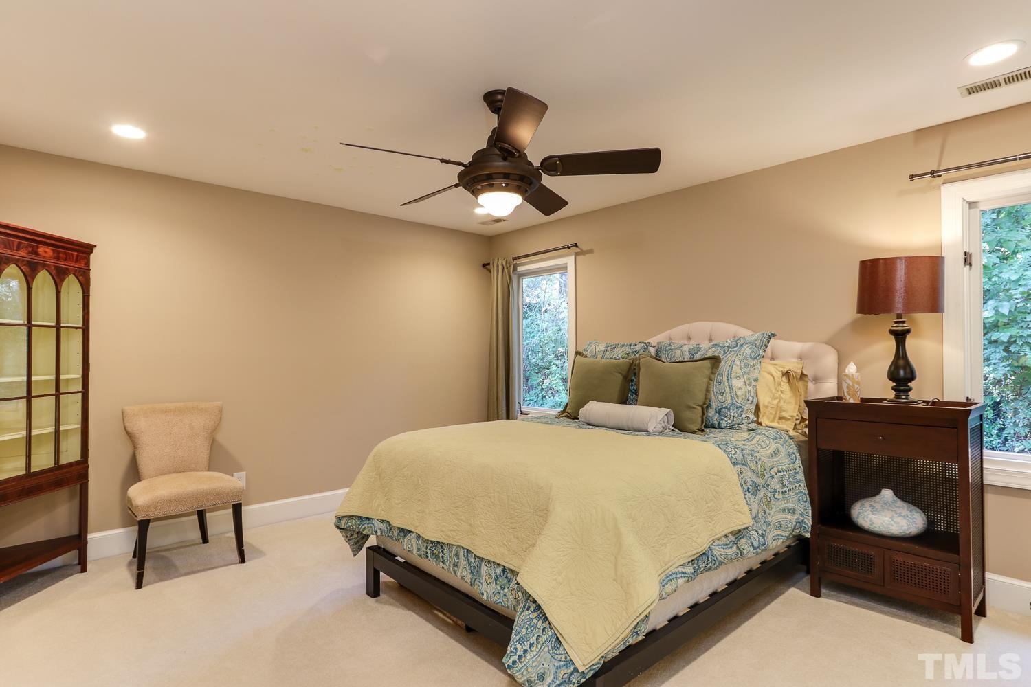 6921 Valley Ridge Court Raleigh, NC 27615 - Photo 22 of 27 a bedroom with a bed and a chandelier