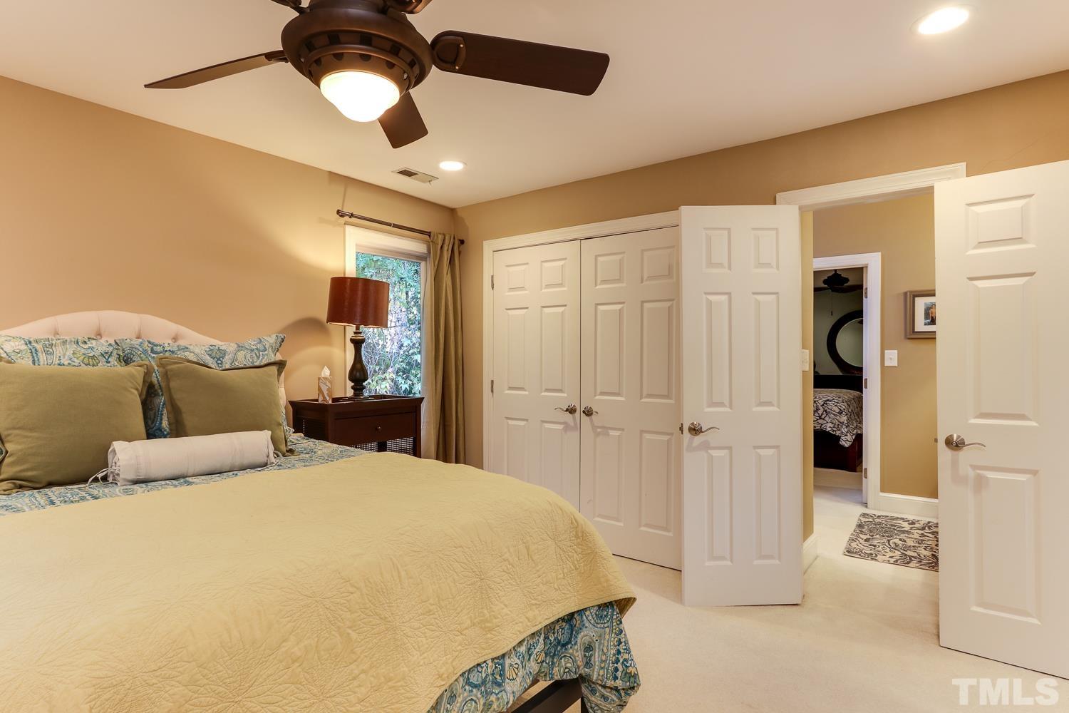 6921 Valley Ridge Court Raleigh, NC 27615 - Photo 23 of 27 a spacious bedroom with a bed and a chandelier