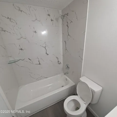 a bathroom with a toilet bathtub and shower