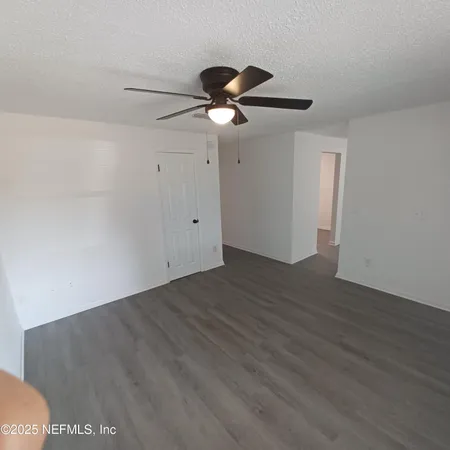 a view of an empty room with wooden floor
