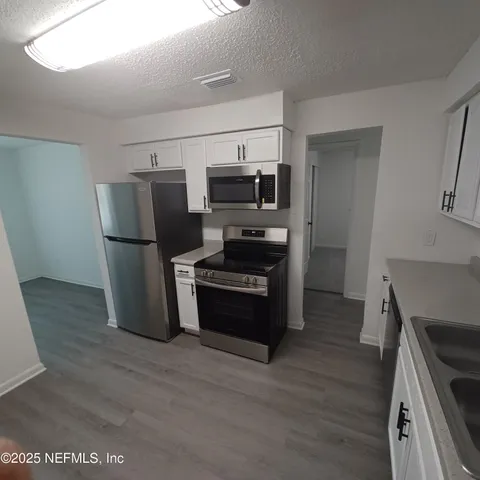 a kitchen with a refrigerator and a stove top oven