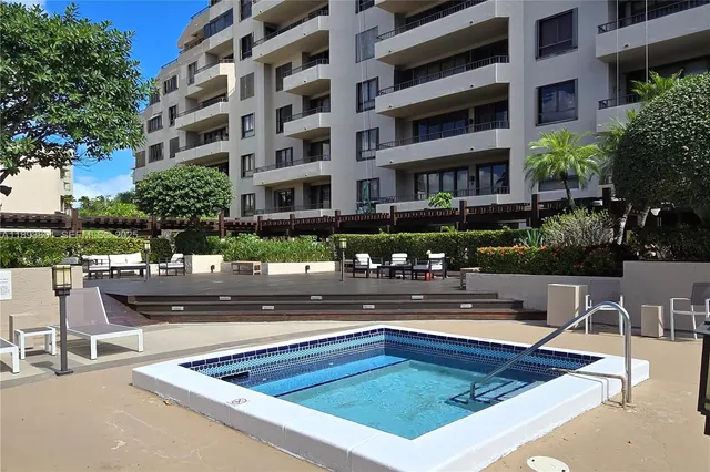 a view of a swimming pool with chairs in front of a building