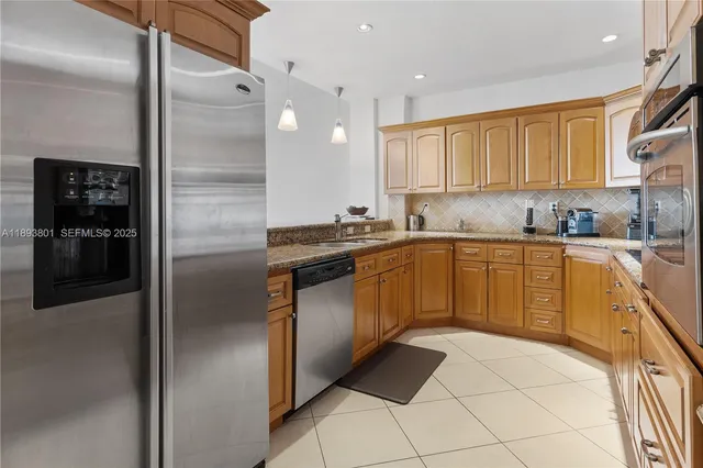 a kitchen with a sink a refrigerator and cabinets