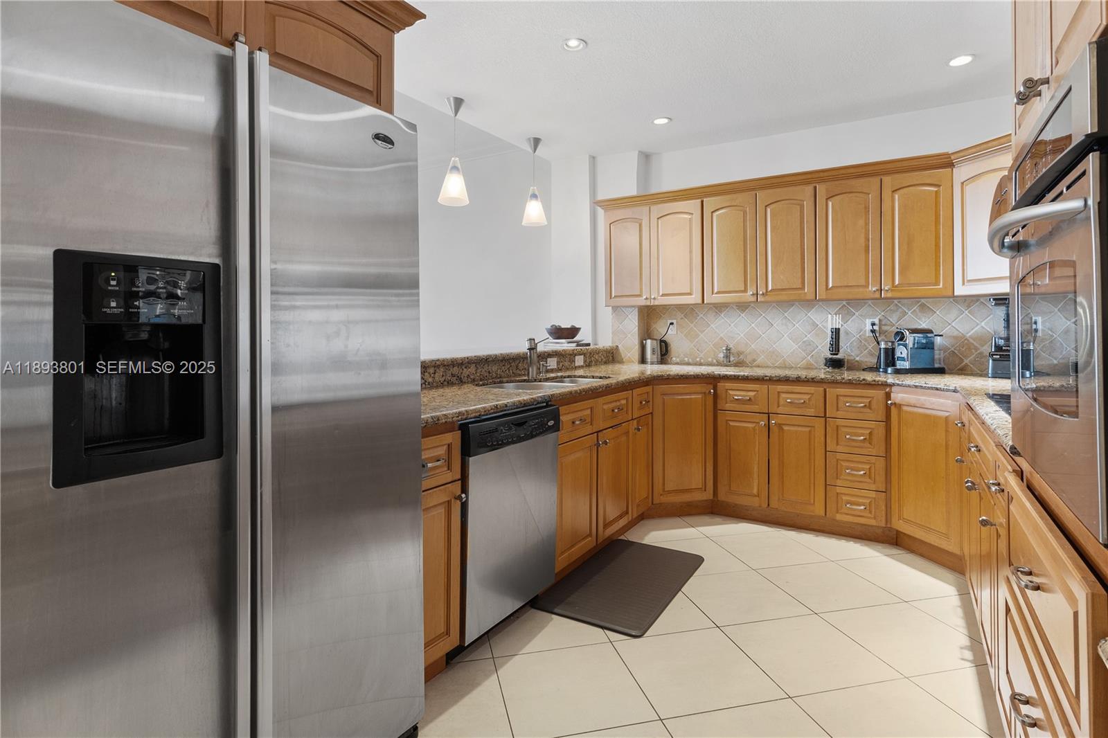 251 Crandon Boulevard, Unit 441 Key Biscayne, FL 33149 - Photo 14 of 28 a kitchen with a sink a refrigerator and cabinets