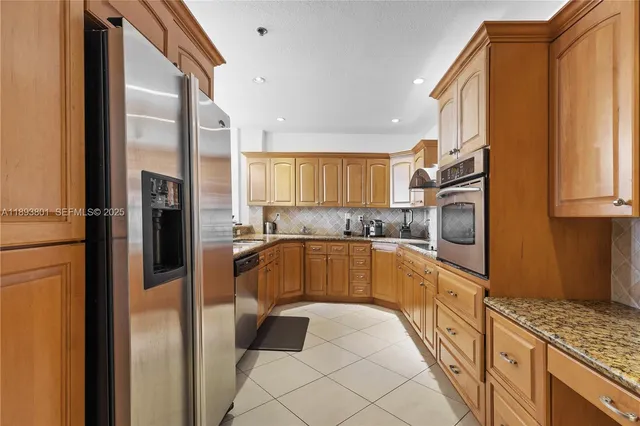 a kitchen with stainless steel appliances granite countertop a refrigerator and a sink