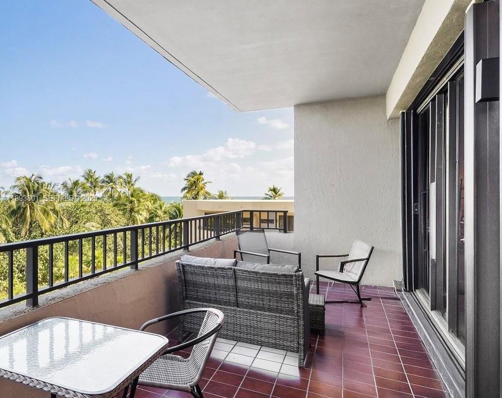 251 Crandon Boulevard, Unit 441 Key Biscayne, FL 33149 - Photo 2 of 28 a balcony with table and chairs