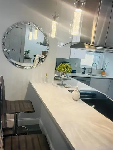 a kitchen with a sink a stove and chairs