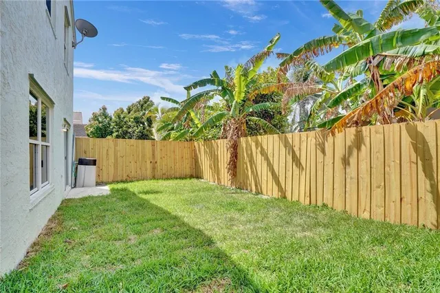 a view of backyard with wooden fence