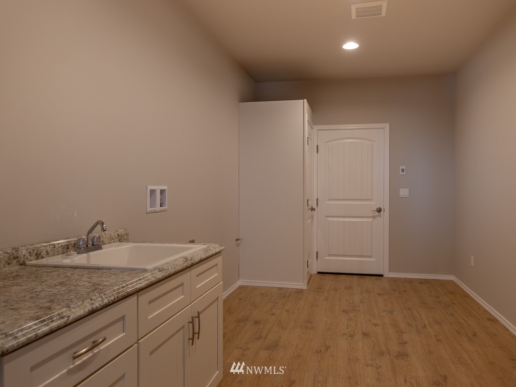1353 Fox Hollow Road Sequim, WA 98382 - Photo 14 of 25 a bathroom with a granite countertop sink and white cabinets