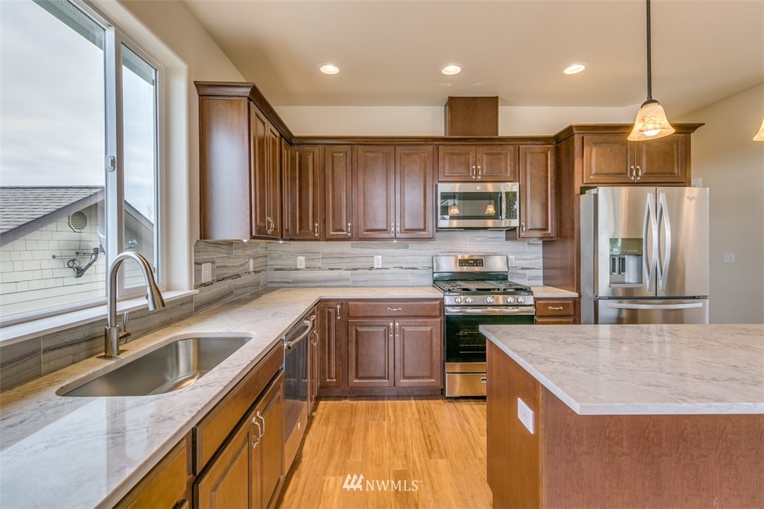 1353 Fox Hollow Road Sequim, WA 98382 - Photo 22 of 25 a kitchen with stainless steel appliances granite countertop a sink a stove and a refrigerator