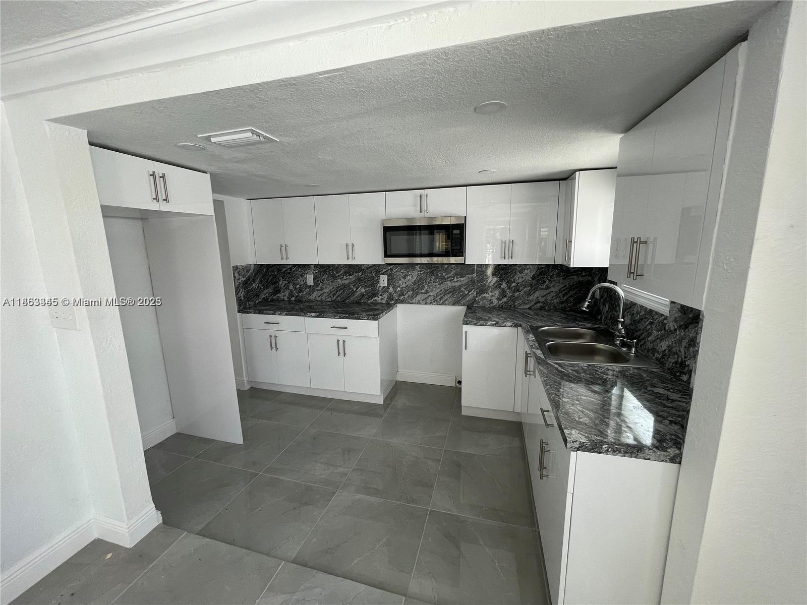 508 East 40th Street Hialeah, FL 33013 - Photo 2 of 8 a kitchen with a sink a stove and refrigerator