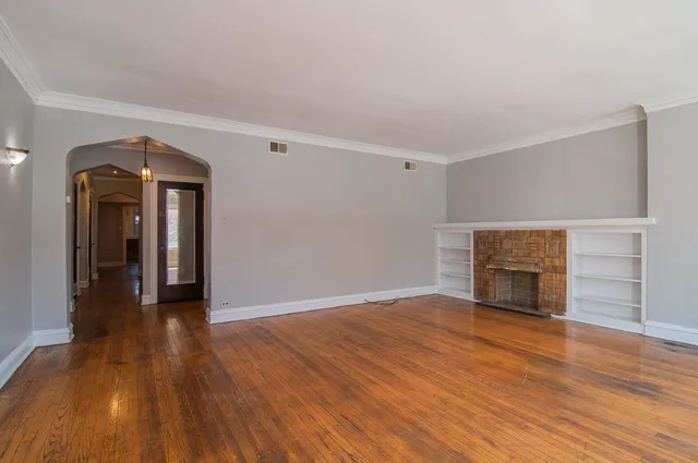 a view of empty room with wooden floor