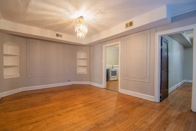 a view of an empty room with wooden floor