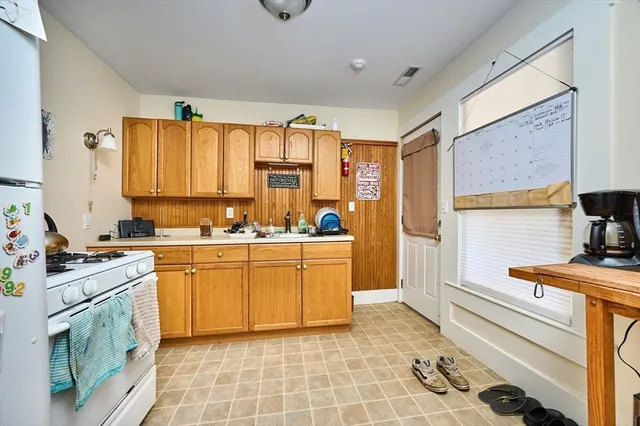 a kitchen with granite countertop a white cabinets and wooden floor